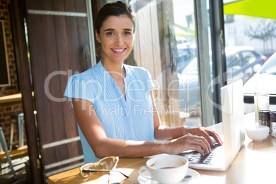 Female executive working on laptop in cafÃ?Â©