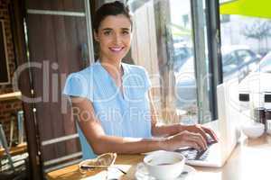 Female executive working on laptop in cafÃ?Â©