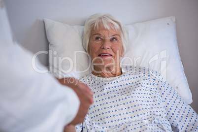 Doctor examining senior patient in ward