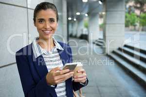 Business executive using mobile phone while having coffee