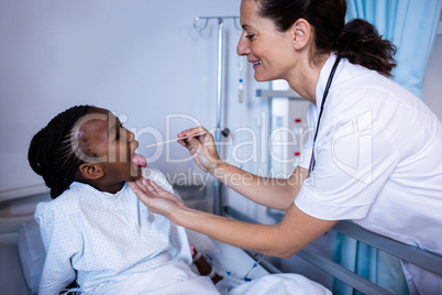 Doctor checking patient fever from thermometer during visit in ward