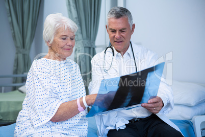 Doctor discussing x-ray report with senior patient