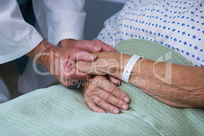 Doctor consoling senior patient in hospital