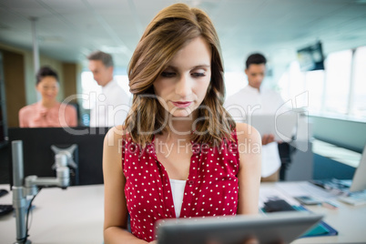 Business executive using digital tablet at desk