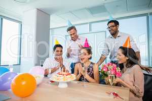 Smiling colleagues celebrating birthday of woman