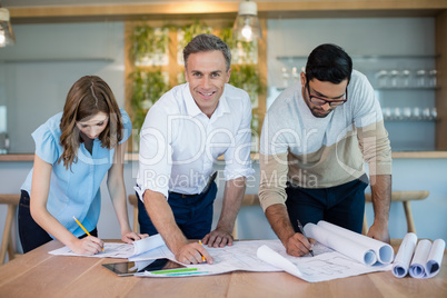 Architects working over blueprint in conference room