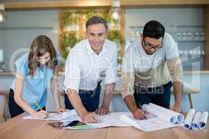 Architects working over blueprint in conference room