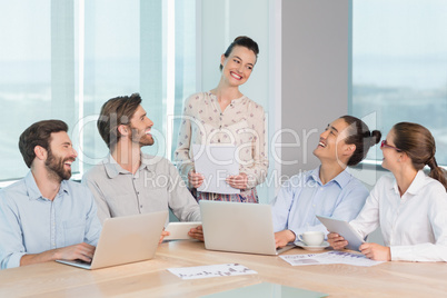 Smiling business executives interacting with each other in conference room