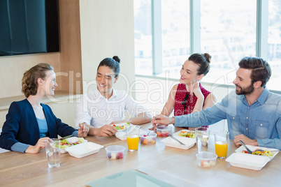 Smiling business executives having meal in office