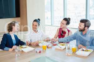 Smiling business executives having meal in office