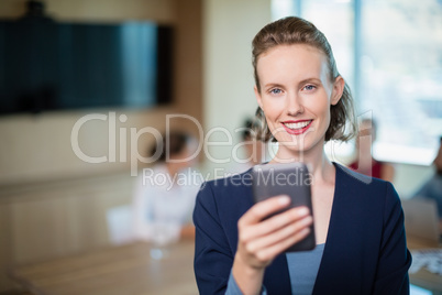Beautiful business executive talking on her mobile phone in conference room