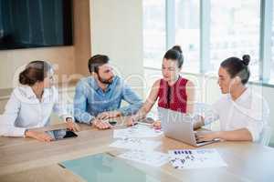 Business executives discussing with each other in conference room