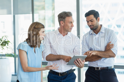 Business executives discussing over digital tablet