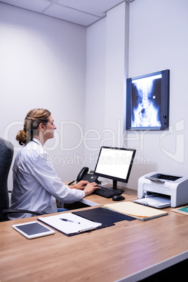 Attentive doctor working on computer in clinic