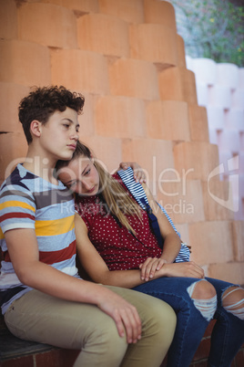 Upset school couple sitting near the steps
