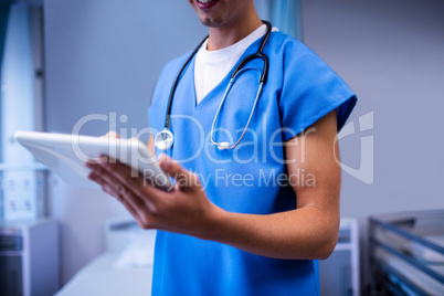 Doctor using digital tablet in ward at hospital