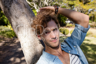 Man relaxing on tree trunk in park