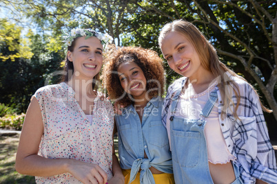 Female friends standing together in park