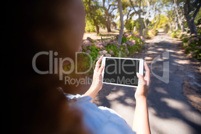 Woman using digital tablet in park