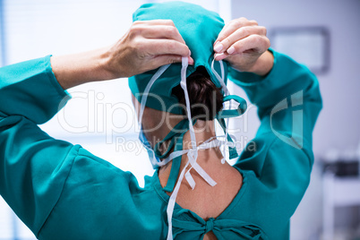 Rear view of female surgeon wearing surgical mask in operation theater