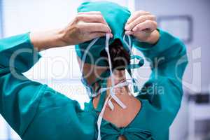 Rear view of female surgeon wearing surgical mask in operation theater