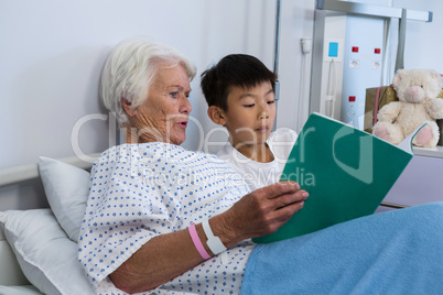 Senior patient and boy reading a book