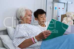 Senior patient and boy reading a book
