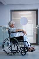 Disabled senior patient on wheelchair in hospital passageway