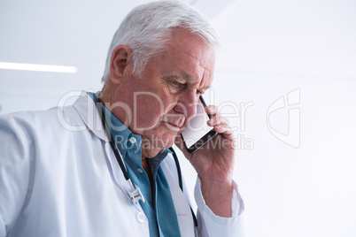 Doctor talking on his mobile phone in the passageway