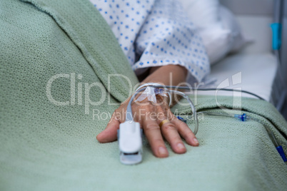 Senior patient hand with saline on bed in hospital