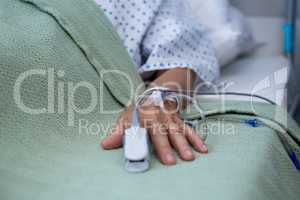 Senior patient hand with saline on bed in hospital