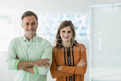 Portrait of smiling business colleagues standing with arms crossed