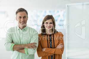 Portrait of smiling business colleagues standing with arms crossed