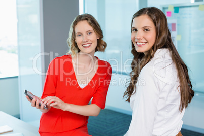 Business executives discussing over mobile phone at office