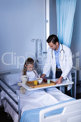 Doctor serving breakfast to girl