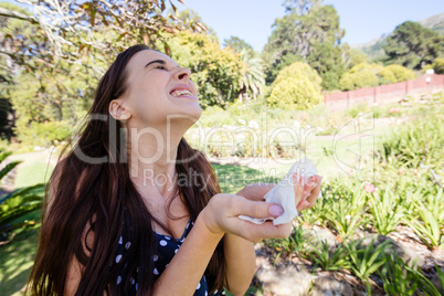 Woman sneezing holding a tissue
