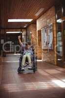 Disabled schoolboy on wheelchair in corridor at school