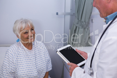 Doctor interacting with senior patient in ward