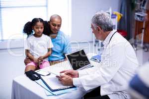Doctor using digital tablet while interacting with patient