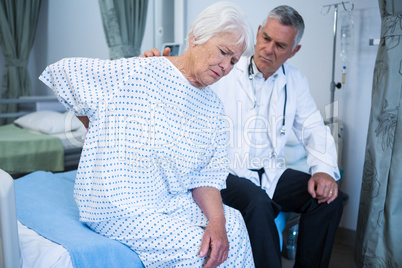 Doctor examining senior patient in ward