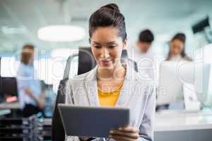 Smiling business executive using digital tablet at desk