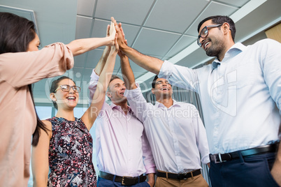 Business colleagues giving high five during meeting in office