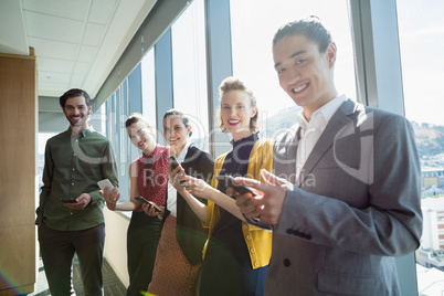 Business executives smiling while using electronic devices