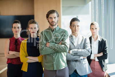 Business executives with arms crossed standing in office