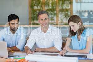 Business executives discussing reports on wooden table