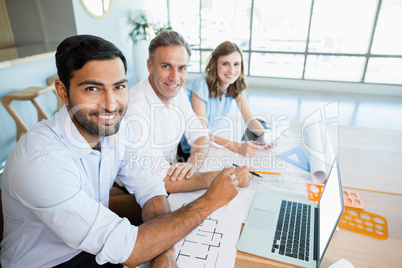 Smiling architects sitting together in conference room