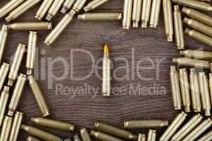 M-16 bullet on wooden table close-up.