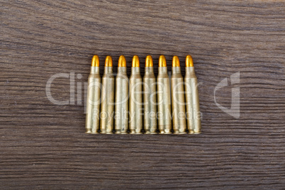 Rifle bullets on wood table.