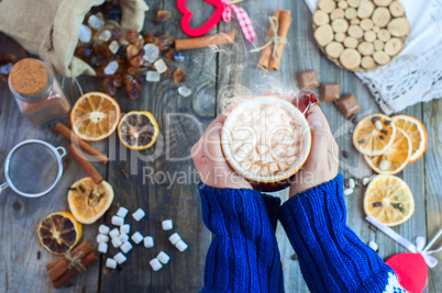 cup of hot chocolate with marshmallows in human hands