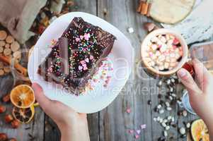 cup of coffee and a plate of cake Sacher in female hands